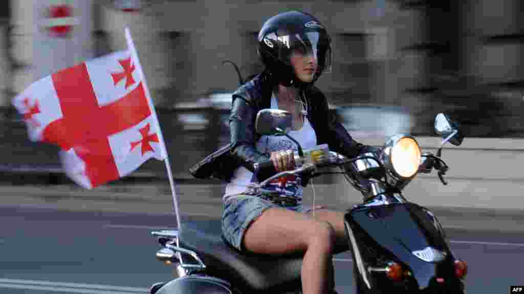 A supporter of the ruling United National Movement party rides a scooter in Tbilisi.