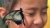 A butterfly lands on the face of a girl during an exhibition dedicated to the insect in the Kyrgyz capital, Bishkek, on October 19. (AFP/Vyacheslav Oseledko)
