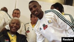 Nelson Mandela shakes hands with South African national team player Teko Modise in Johannesburg during the lead-up to the World Cup.