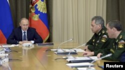 Russia - Russian President Vladimir Putin (L) chairs a meeting with senior officials of the Defense Ministry and representatives of the military industrial complex at the Bocharov Ruchei state residence in Sochi, with Defence Minister Sergei Shoigu (C) an