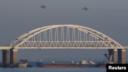 Russian fighters fly over the bridge connecting the Russian mainland with the Crimean Peninsula after three Ukrainian Navy vessels were stopped by Russian ships on November 25.