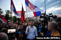 Bosko Obradovic waves a Serbian flag during protests in Belgrade in 2020.