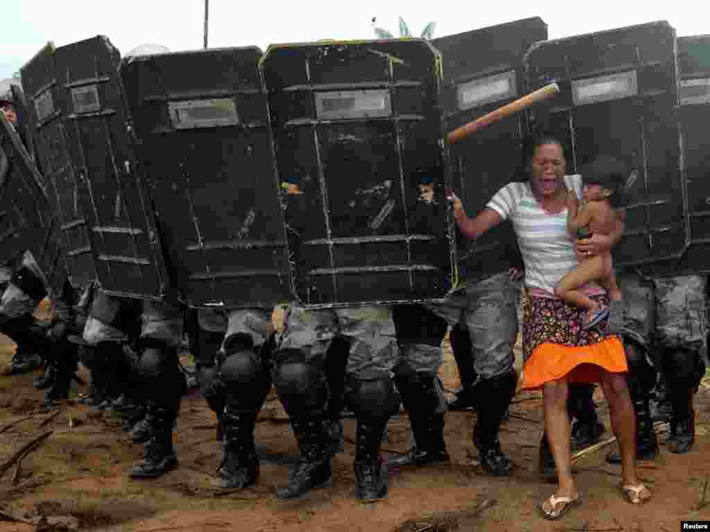 An indigenous woman holds her child while trying to resist the advance of Amazonas state policemen who were expelling the woman and some 200 other members of the Landless Movement from a privately-owned tract of land on the outskirts of Manaus, in the heart of the Brazilian Amazon March 11, 2008. The landless peasants tried in vain to resist the eviction with bows and arrows against police using tear gas and trained dogs. REUTERS/Luiz Vasconcelos-A Critica/AE 