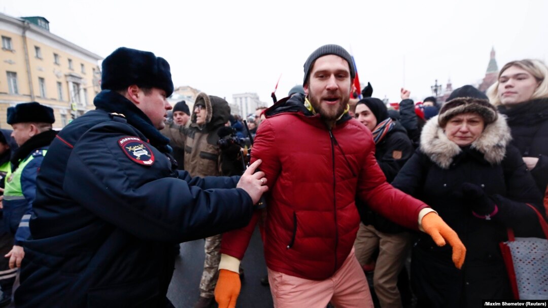 Moskva, policajac zadržava demonstranta