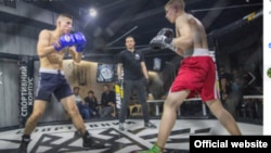 Robert Rundo (in blue) fights a cage match against a Ukrainian Azov member in Kyiv in 2018.