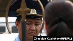 Полицейский у ворот здания комитета уголовно-исполнительной системы беседует с родственниками заключенных. Астана, 14 августа 2010 года. Иллюстративное фото.