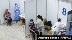 Două femei sunt vaccinate în cadrul „Maratonului vaccinării” COVID 19, de Ziua Europei la Biblioteca Națională din București.