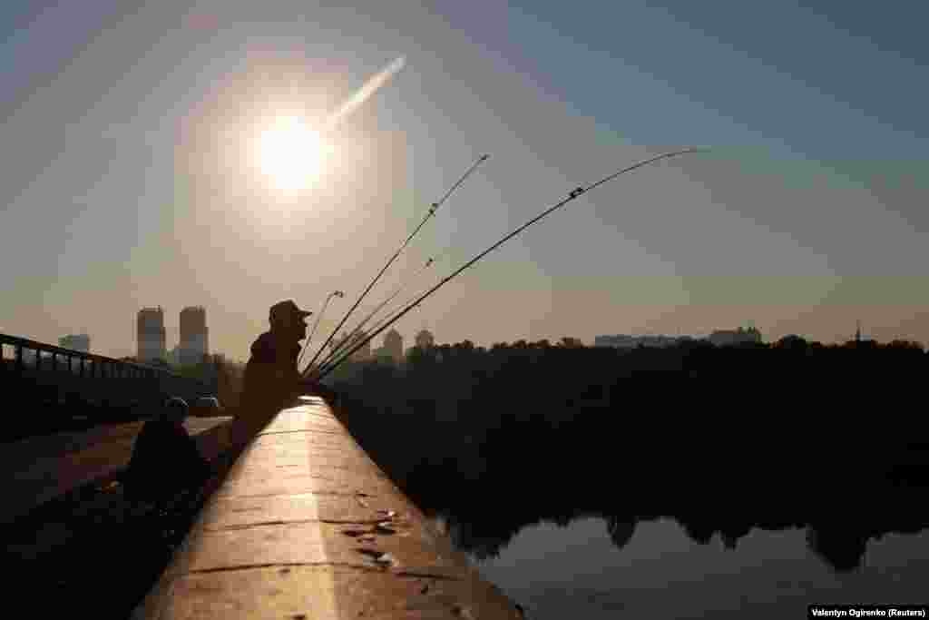 Fishermen wait for the fish to bite on a bridge over the Dnipro River in the early hours of the morning in the Ukrainian capital, Kyiv. (Reuters/Valentyn Ogrienko)