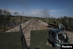 Membri ai unei unități de voluntari străini care luptă în armata ucraineană se deplasează pe un vehicul militar în Sievierodonețk, regiunea Luhansk din Ucraina, 2 iunie 2022.