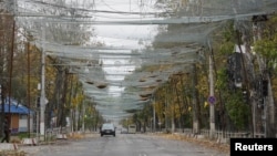 Вуліца ў Херсоне, зацягнутая антыдронавай сеткай з апалым лісьцем на ёй, 27 кастрычніка 2026