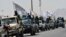 Taliban fighters atop vehicles with Taliban flags parade along a road in Kandahar on September 1 to celebrate after the United States completed its withdrawal from Afghanistan.