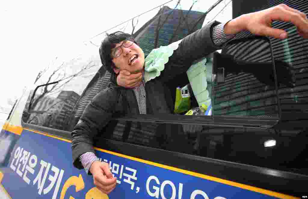 South Korean policemen detain a protester who was one of several demonstrators who tried to enter the Japanese Embassy in Seoul on December 31. (epa/Yang Ji-Woong)