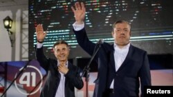 Bidzina Ivanishvili (left) and Prime Minister Giorgi Kvirikashvili wave at a Georgian Dream rally after the first round of the parliamentary elections in Tbilisi on October 8.