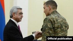 Armenia - President Serzh Sarkisian gives a medal to a soldier serving in Nagorno-Karabakh, Yerevan, 28Dec2014.