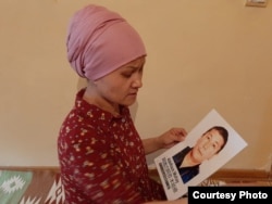 Бикамал показывает портрет мужа, с которым она выходит на акции протеста у консульства Китая в Алматы