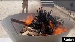 Luftëtarët e PKK-së duke i djegur armët gjatë një ceremonie në Kurdistan.