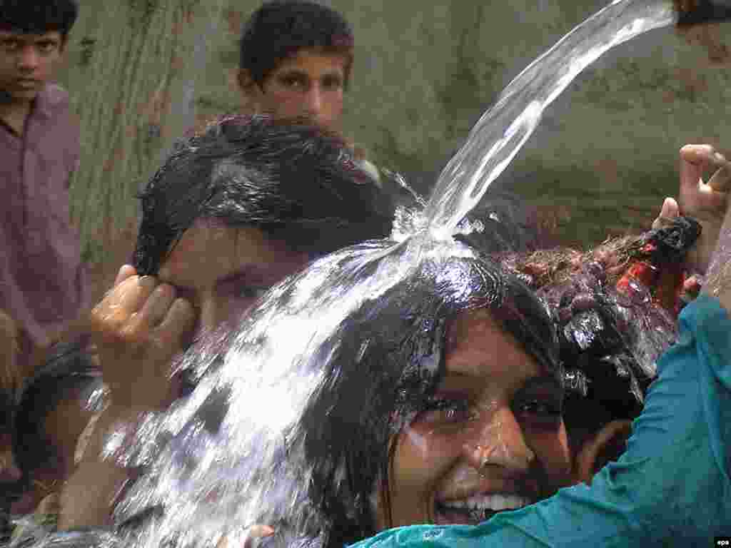 Flood victims cool off at a community tap near their temporary shelters in Larkana, Sindh Province, Pakistan on August 19. The United Nations warned on 16 August that up to 3.5 million children were at risk from water-borne diseases in flood-hit Pakistan and said it was bracing to deal with thousands of potential cholera cases. Photo by Fawad Hussein for epa