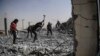 Syrians clear the rubble of their houses that were destroyed during clashes on the outskirts of Raqqa.