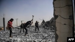 Syrians clear the rubble of their houses that were destroyed during clashes on the outskirts of Raqqa.