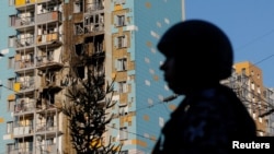 Russian security forces stand guard near a damaged residential area following a Ukrainian attack on the Moscow region.