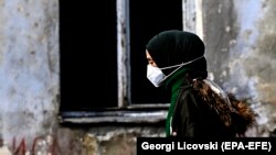Fotografi ilustruese: Një grua me maskë duke ecur në një rrugë të Shkupit.