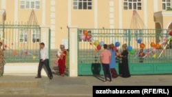 Türkmenistandaky bilim edaralarynyň biriniň öňündäki ene-atalar (Arhiwden alnan illýustrasiýa suraty)