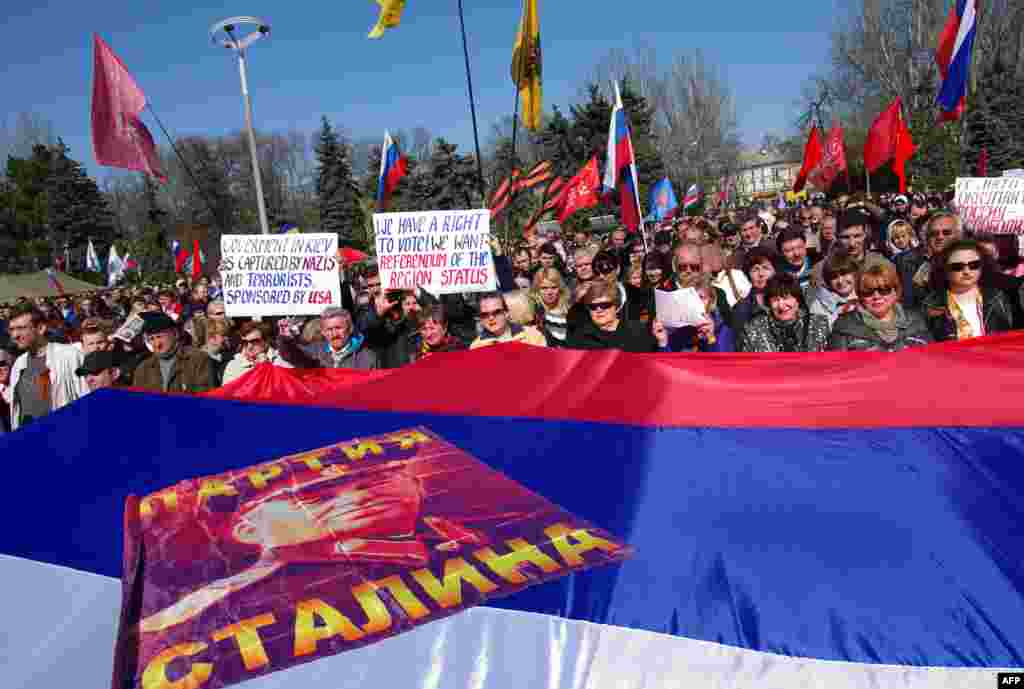 Pro-Russian activists hold a large Russian flag bearing a portrait of late Soviet dictator Josef Stalin as they take part in a rally in Odesa, Ukraine. (AFP/Aleksei Kravtsov)