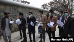 Activists wearing face masks prepare for a campaign to raise awareness of the new coronavirus in Kabul on  March 16.