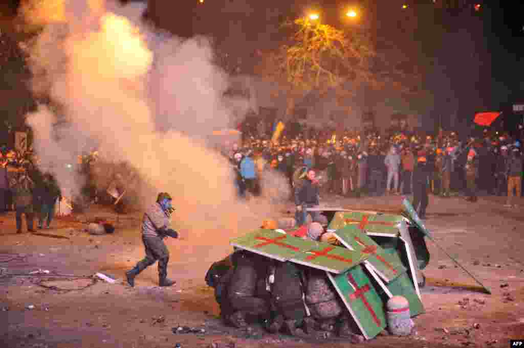 Ukraine -- Protesters protect themselves as they clash with riot police, Kyiv, 19Jan2014