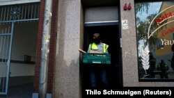 Njemački policajac napušta kuću tokom pretresa protiv navodnih islamističkih ekstremista u Duerenu kod Kelna, Njemačka, juli 18, 2019.