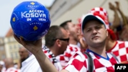 A Croatian supporter holds a ball saying, "Accept Kosovo in UEFA" in Poznan, Poland, during the European soccer finals in 2012.