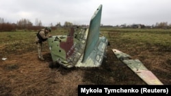 Українські військові оглядають уламки російського літака Су-25, архівне фото, квітень 2022 року