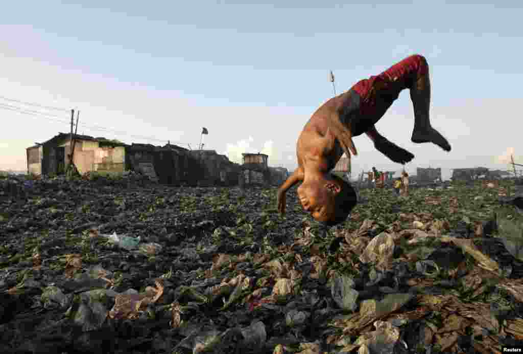A boy plays in a garbage dump where hundreds of people live and earn money by recycling waste and making charcoal in Manila, the Philippines.