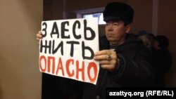 Житель села Березовка демонстирует плакат на встрече с заместителем министра энергетики Узакбаем Карабалиным. Западно-Казахстанская область, 20 января 2015 года.