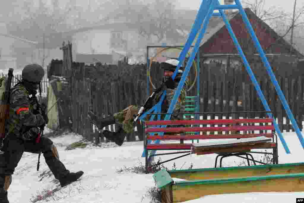 A Ukrainian serviceman of the Donbas volunteer battalion rides a swing in a village in the Lysychansk district of the Luhansk region. (AFP/Anatoli Boiko)