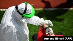 A Kosovar soccer referee gets tested for COVID-19 at a stadium in Pristina.