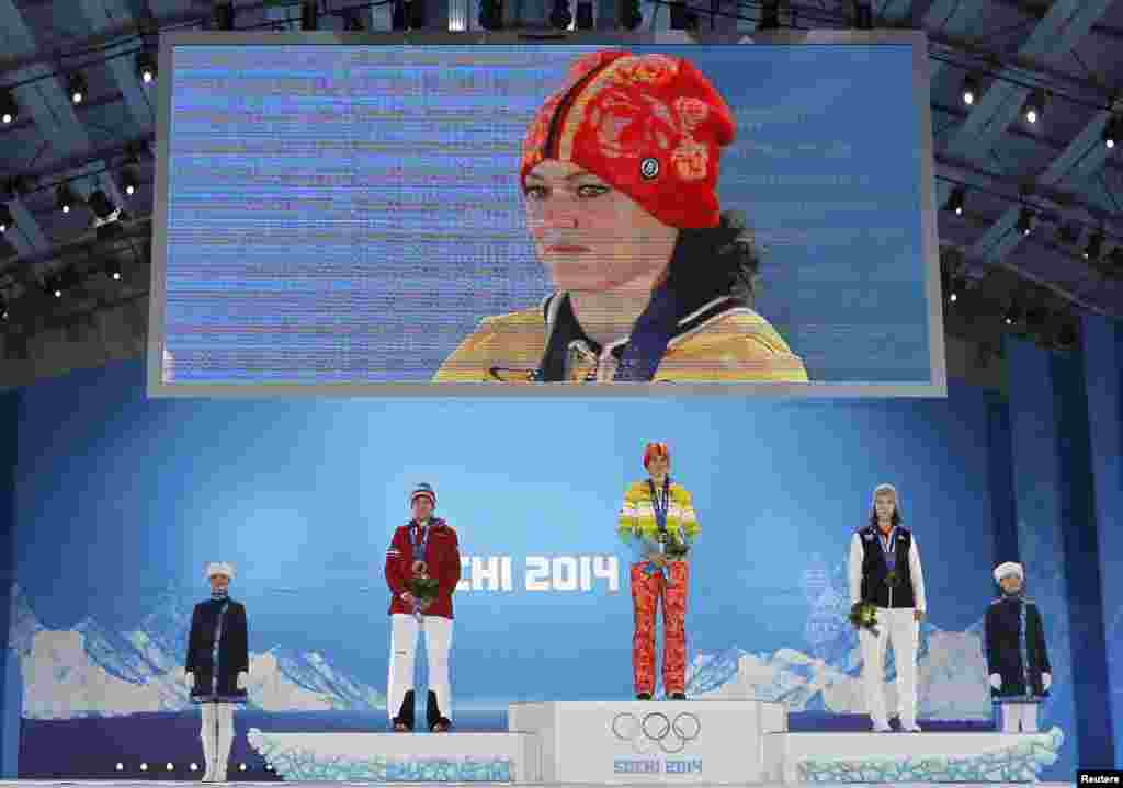 Gold-medalist Carina Vogt of Germany, silver-medalist Daniela Iraschko-Stolz of Austria, and bronze-medalist Coline Mattel of France stand during the medal ceremony for the women&#39;s ski-jumping individual normal hill event.