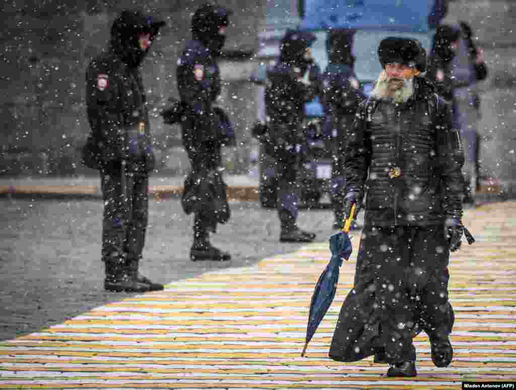 A Russian Orthodox priest walks past a police line blocking the access to Red Square during a rehearsal for the upcoming parade on October 26. (AFP/Mladen Antonov)