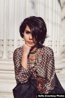 Safia wears a traditional handmade orange colored Afghan choker-style necklace. Choker-style necklaces are staple Afghan jewelry pieces, mostly made of metal, silver, or sometimes gold plated silver.