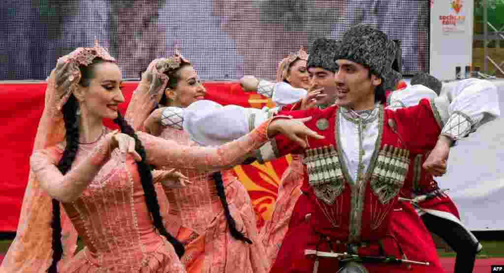 رقصنده ها با لباس شمال قفقاز در جریان مراسم انتقال مشعل المپیک زمستانی در داغستان