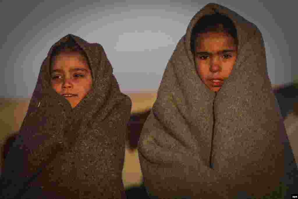 Internally displaced Afghan children stand outside a temporary shelter in Herat as temperatures signal the coming of winter. (EPA/Jalil Rezayee)