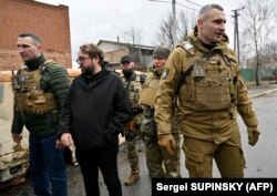 Vitalij Klicsko kijevi polgármester (jobbra) március 31-én az orosz hadsereg alól felszabadított Bucsa városában, ahol több száz halott civilt találtak. Balra testvére, Volodimir Klicsko. 2022. április 3.
