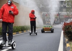 Оператори супроводжують робот-дезінфектор на вулицях міста Ухань, Китай, березень 2020 року