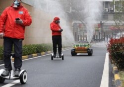 Оператори супроводжують робот-дезінфектор на вулицях міста Ухань, Китай, березень 2020 року