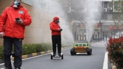 Операторы сопровождают робот-дезинфектор на улицах города Ухань, Китай, март 2020 года