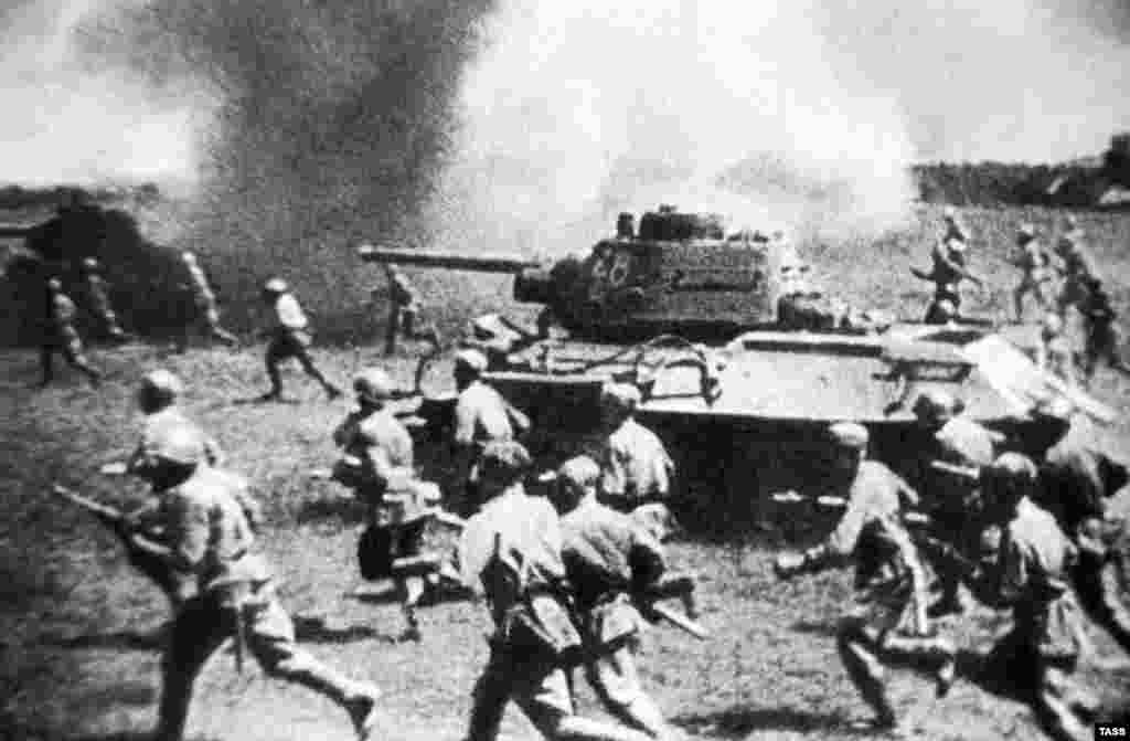 Soviet troops follow their T-34 tanks during an attack against German forces during the Battle of Kursk, 1943.