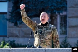 Dressed in military fatigues, Azerbaijani President Ilham Aliyev gives a speech on November 8 during a parade dedicated to the third anniversary of Baku's victory in Nagorno-Karabakh in 2020.