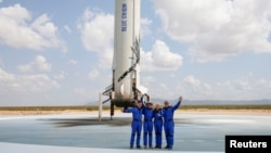 Milijarder Jeff Bezos (drugi slijeva) pozira sa članovima posade nakon uspješno obavljenog leta u svemiru, Teksas (20. juli 2021.)