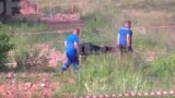 Сотрудники силовых структур уносят тело Романа Старовойта с места его предполагаемого самоубийства, 7 июля 2025 года