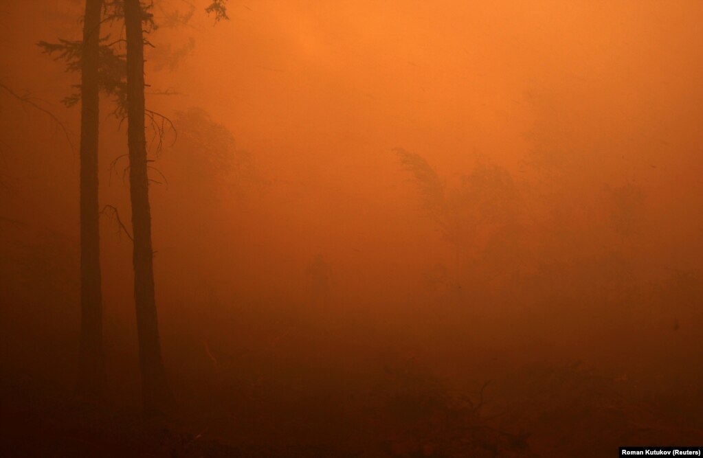 Një zjarrfikës, mes një mjegulle të portokalltë, duke u angazhuar për shuarjen e një zjarri pyjor afër fshatit të Magarasit, në rajonin e Jakutisë, në Rusi. (17 korrik)